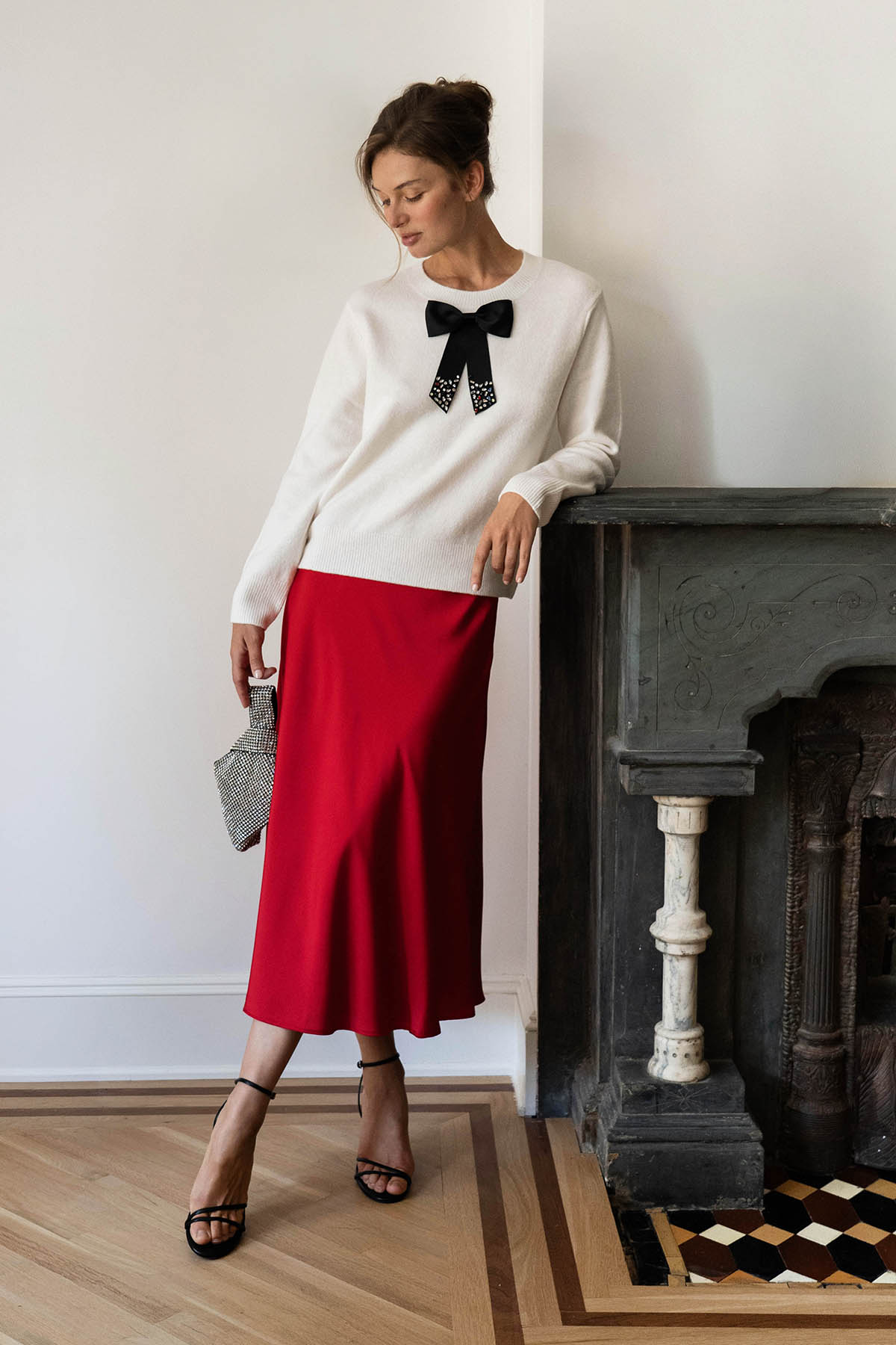 A woman wearing a black dress and a brown bow tie.