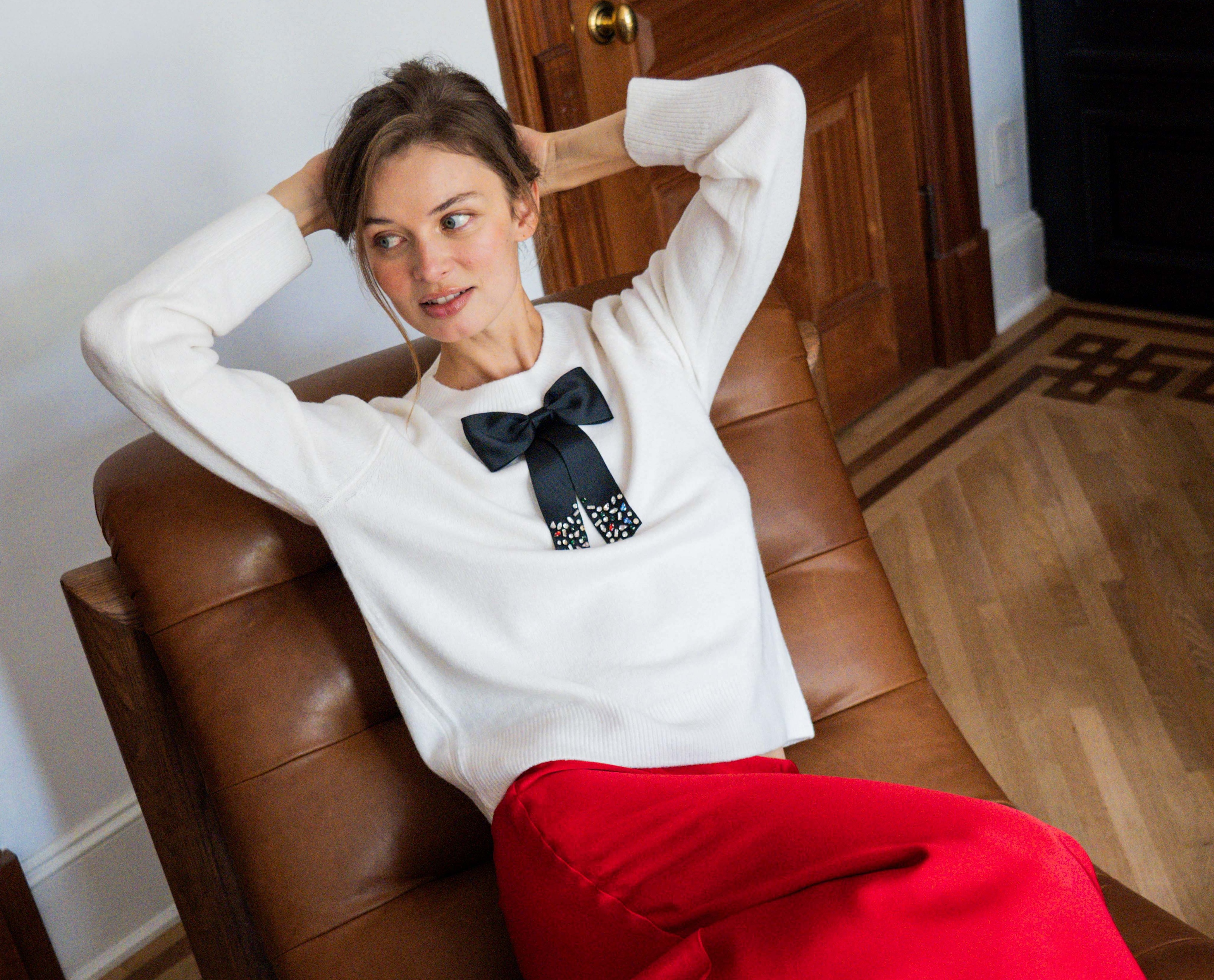 A woman wearing a black and white shirt with a bow around her neck.