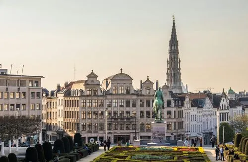 Vue de la Grand-Place de Bruxelles au coucher du soleil avec la statue équestre de Charles de Lorraine et les bâtiments historiques.