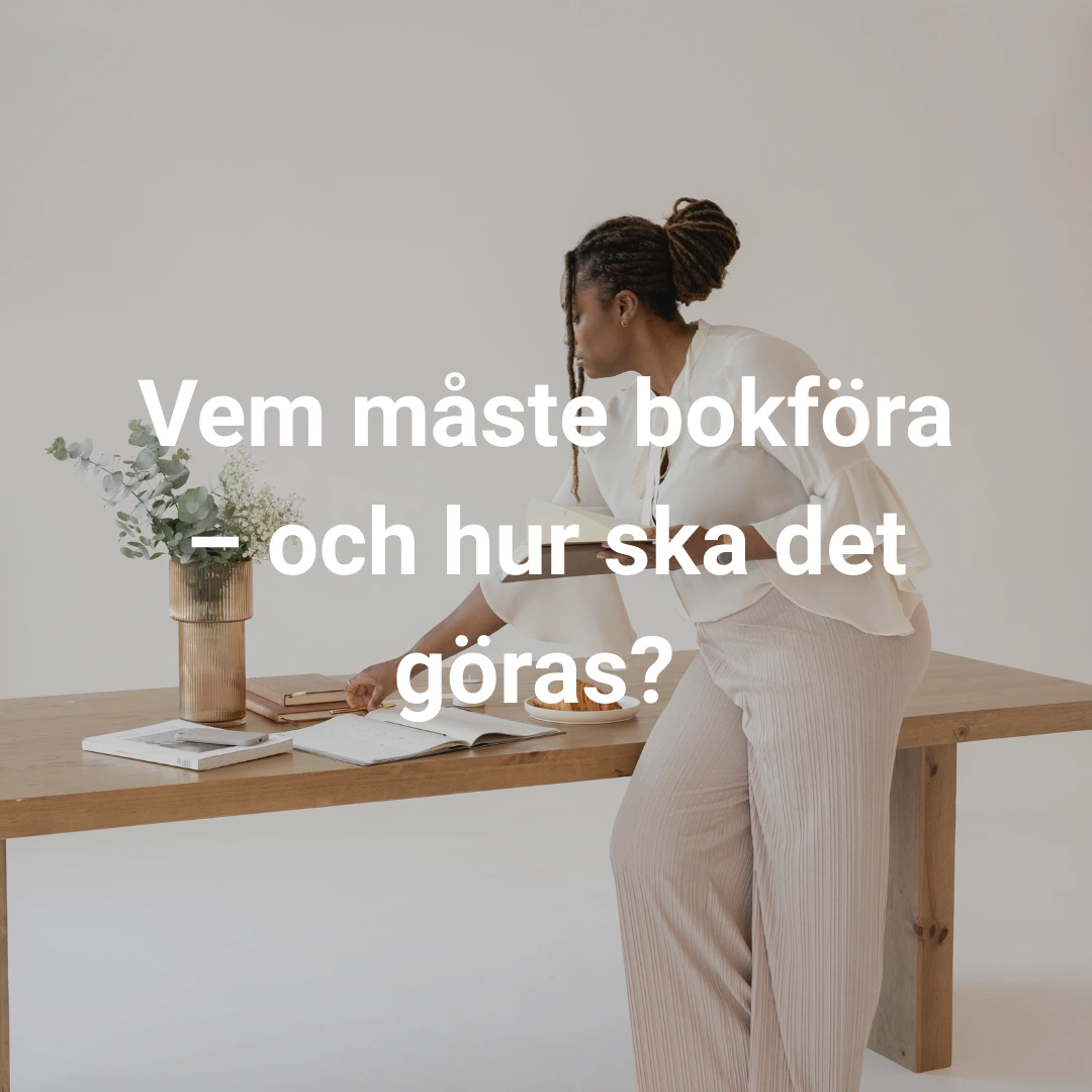 Kvinna med ljus klädsel som sitter på ett bord med papper framför sig 