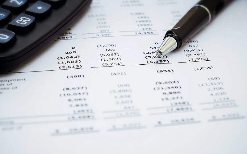 Ett papper med en massa siffror på och en penna som ligger brevid 