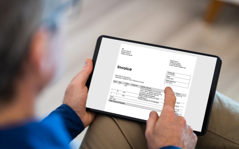 Man som sitter och skapar en faktura på en ipad 