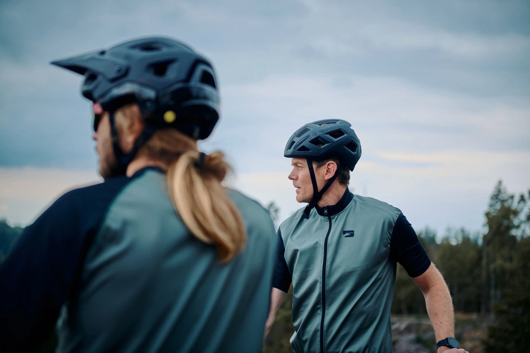 En man med cykelkläder och hjälp redo för att cykla.