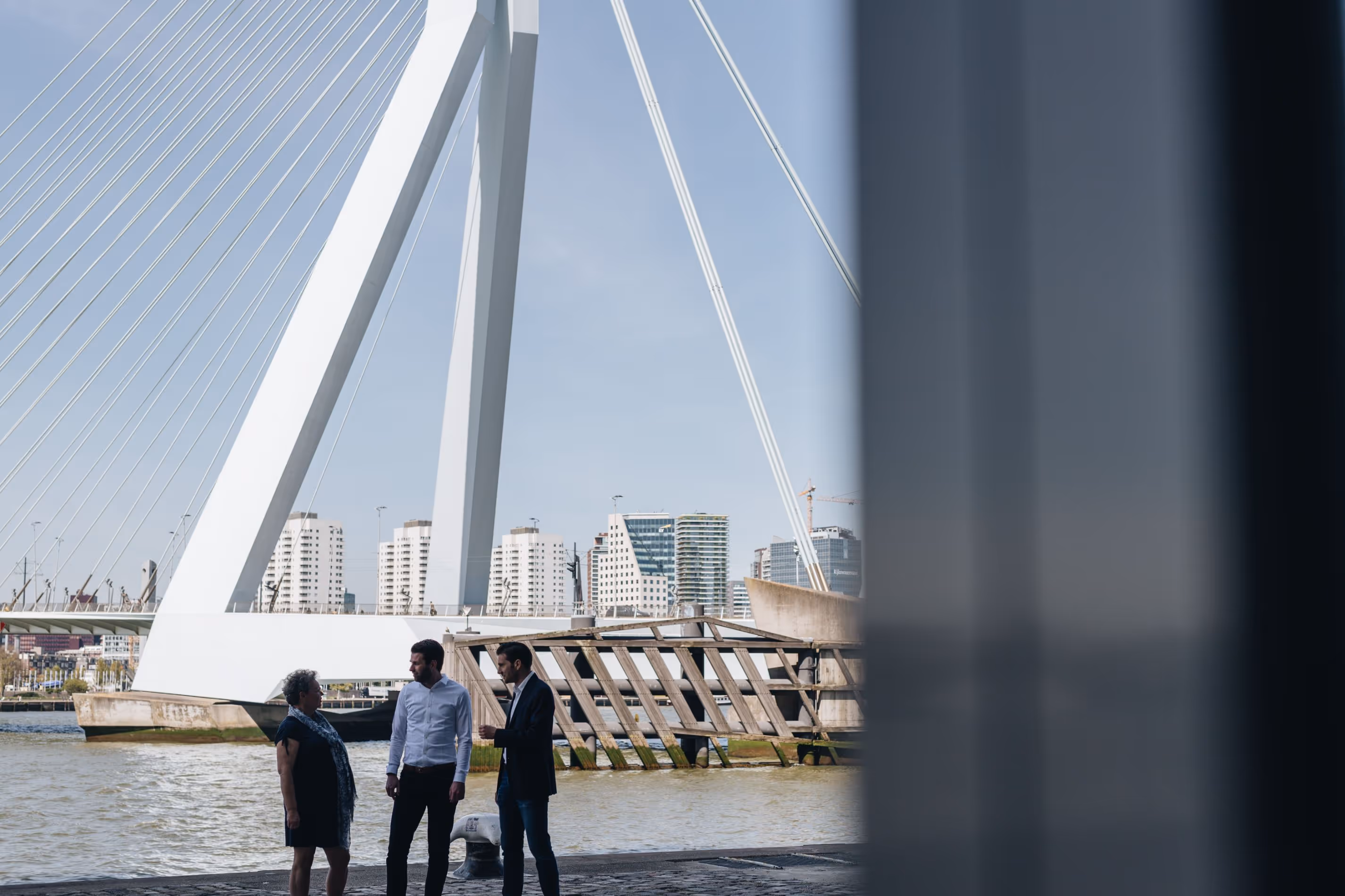Mendix consultants in gesprek bij de erasmus brug in rotterdam