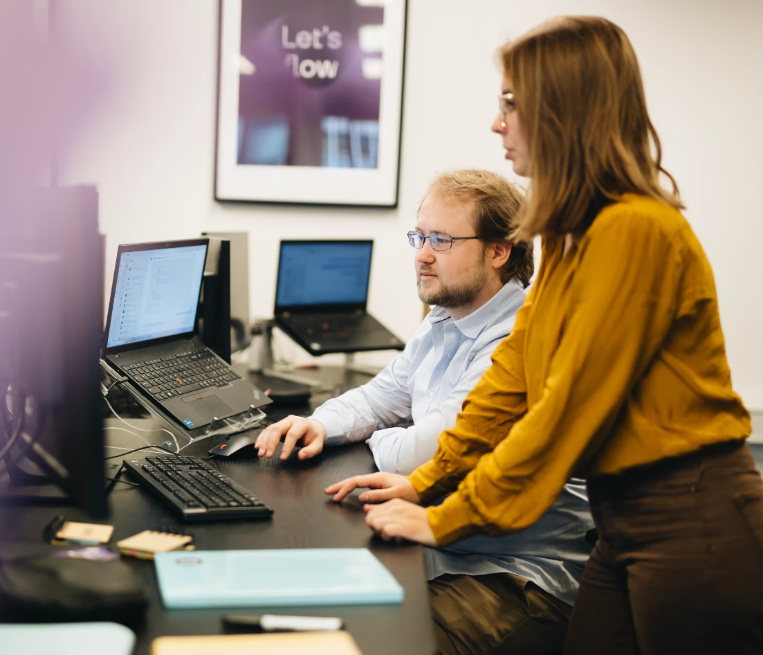 Twee werknemers discussiëren over de AI-implementatie bij een klant