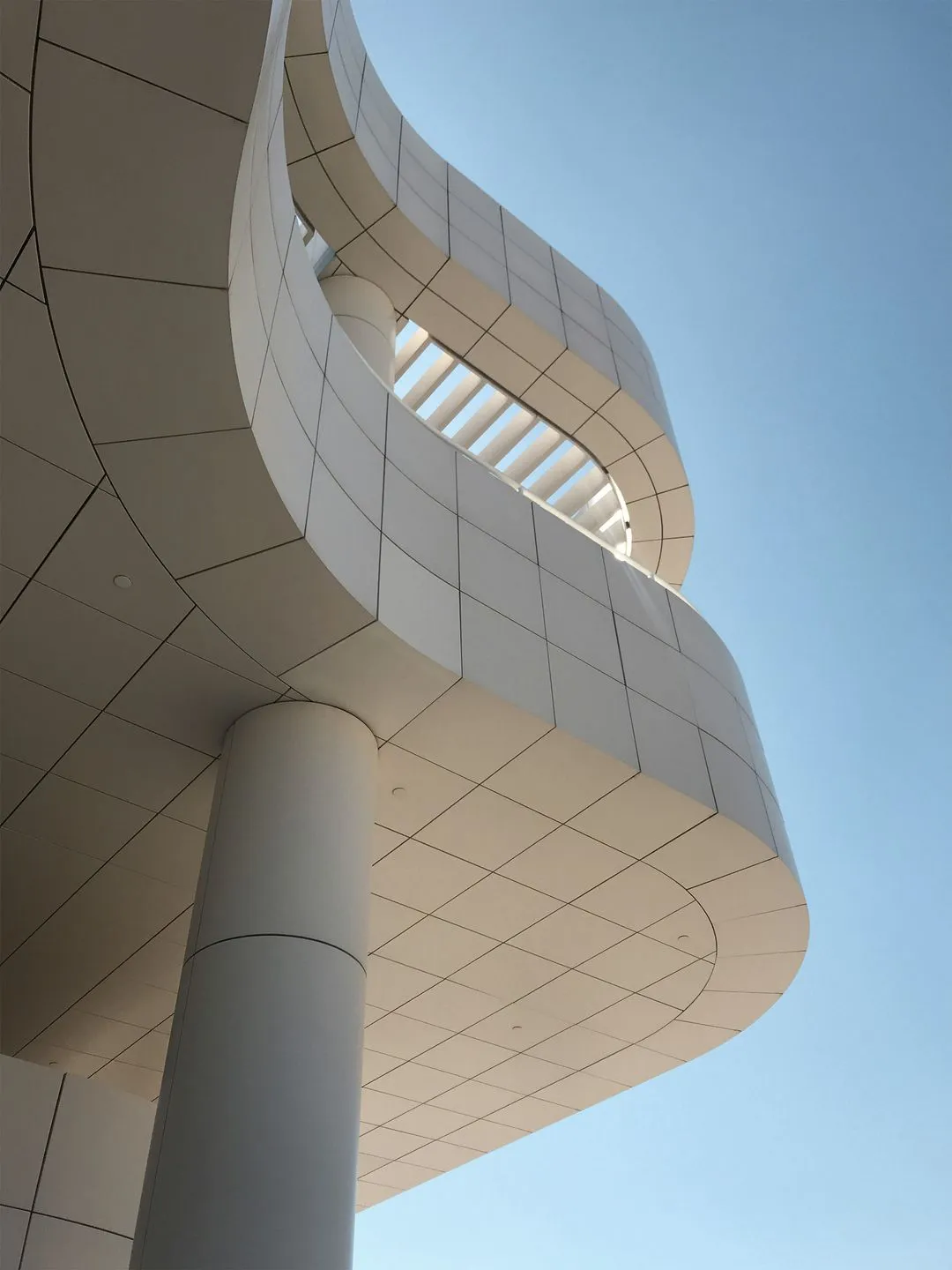 Sculptural building with flowing, organic shapes and a striking mix of glass, steel, and concrete materials