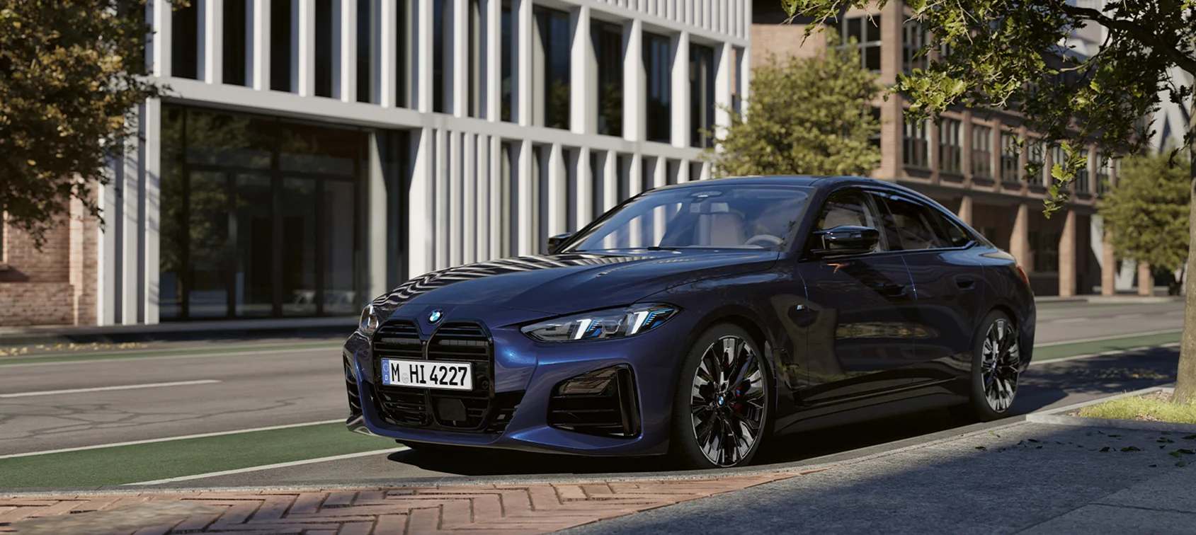 BMW i4 in Blau auf urbaner Straße mit moderner Architektur im Hintergrund – BMW Köhler in Karlstadt