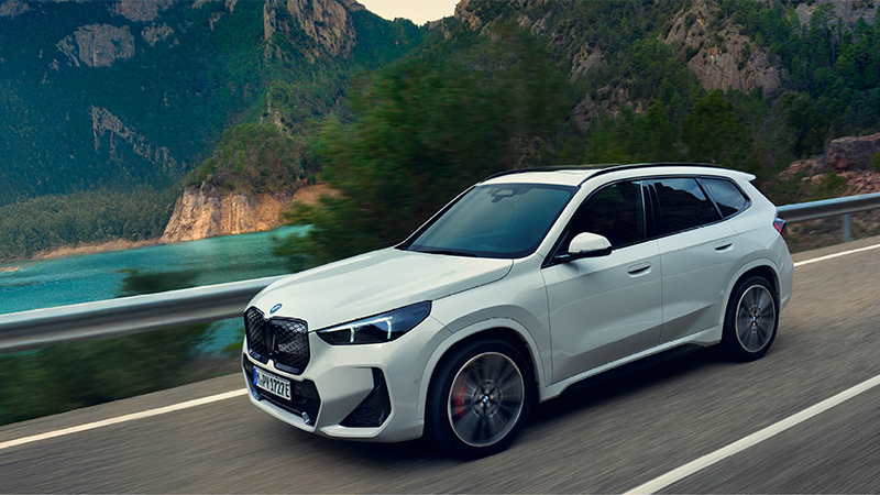 Weißer BMW iX1 SUV mit markanter Front fährt aus einer Tiefgarage ins Sonnenlicht – BMW Köhler in Karlstadt