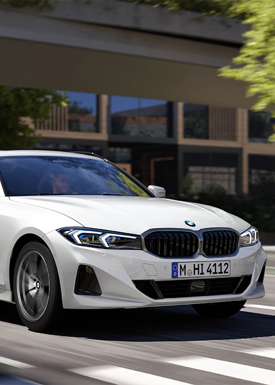 Weißer BMW 3er Touring in Bewegung auf urbaner Straße unter moderner Architektur – BMW Köhler in Karlstadt