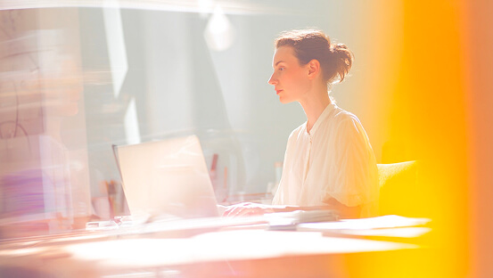 A lady at her desk learning in a virtual classroom