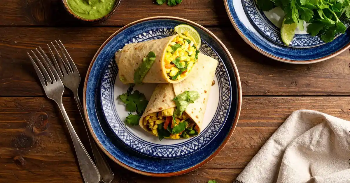 Protein-Wraps mit Eiweiß-Omelett, Gemüse und Koriander-Erdnuss-Dip angerichtet auf modernen Tellern
