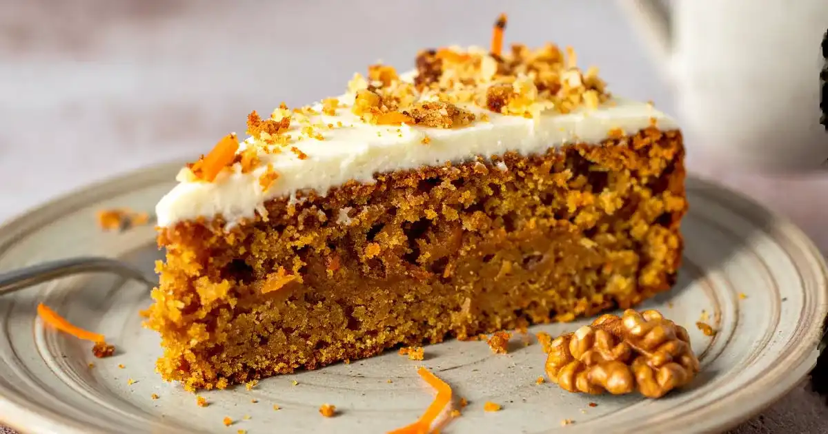 Proteinreicher Karottenkuchen mit Frosting und Walnüssen auf Holzplatte