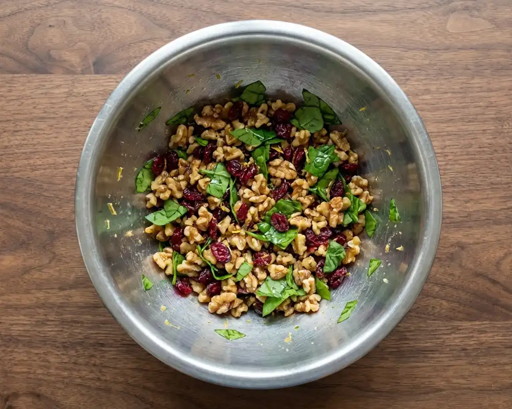 Walnuss-Cranberry-Topping mit Babyspinat in Edelstahlschüssel