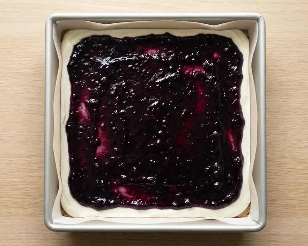 Geschichtete Cheesecake-Masse mit Heidelbeerschicht in Backform von oben