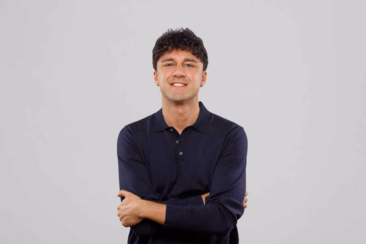 Banxware team member portrait Mandya, young, brown-haired man with broad smile in dark clothing