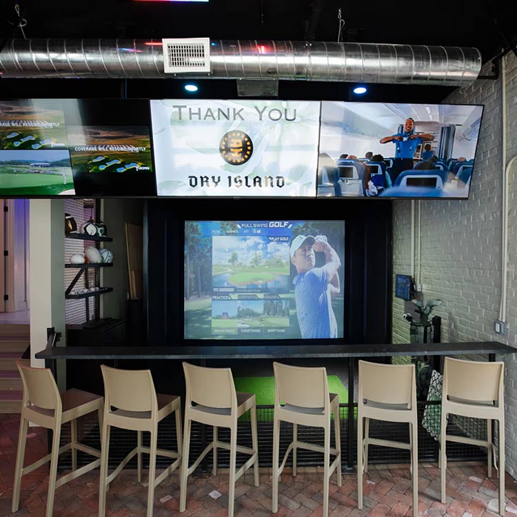 Indoor Full Swing golf and sports simulator bay at The Yard in Ocean City, NJ, with seating for a rainy-day session
