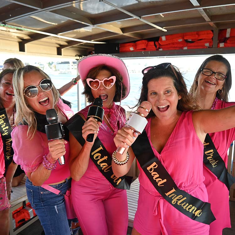 Bachelorette party group celebrating with microphones on a Beachy Tiki boat cruise in Ocean City, NJ