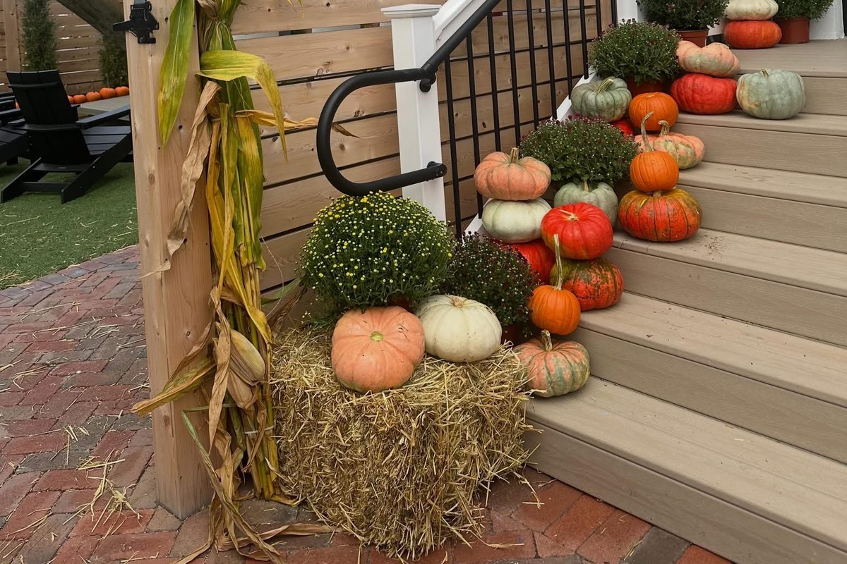 Entrance stairs at The Yard in Ocean City, NJ decorated for fall with pumpkins, mums, hay bales and corn stalks