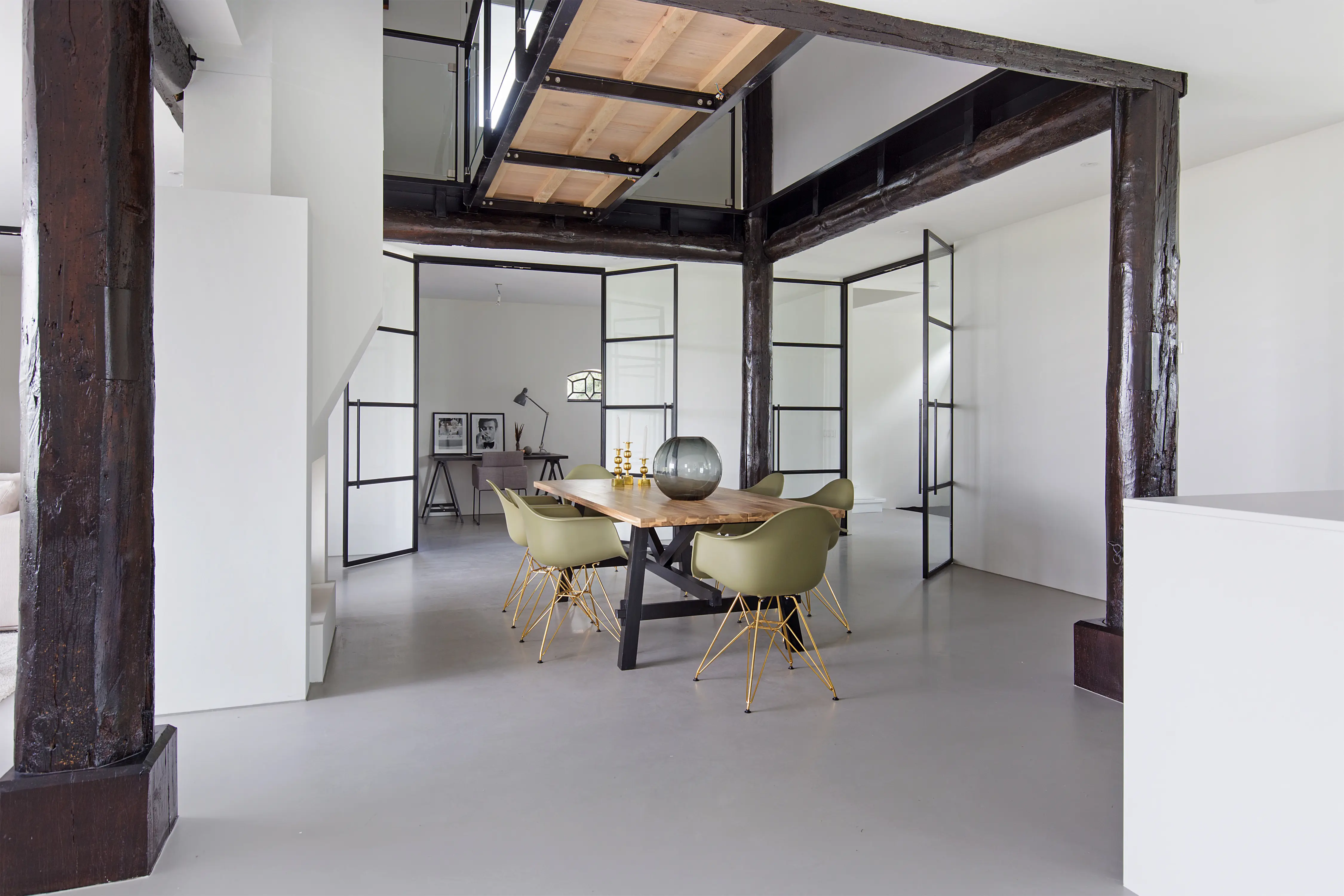 Gerestaureerde boerderij met modern interieur met hoge glazen deuren gecombineerd met traditionele houten balken.