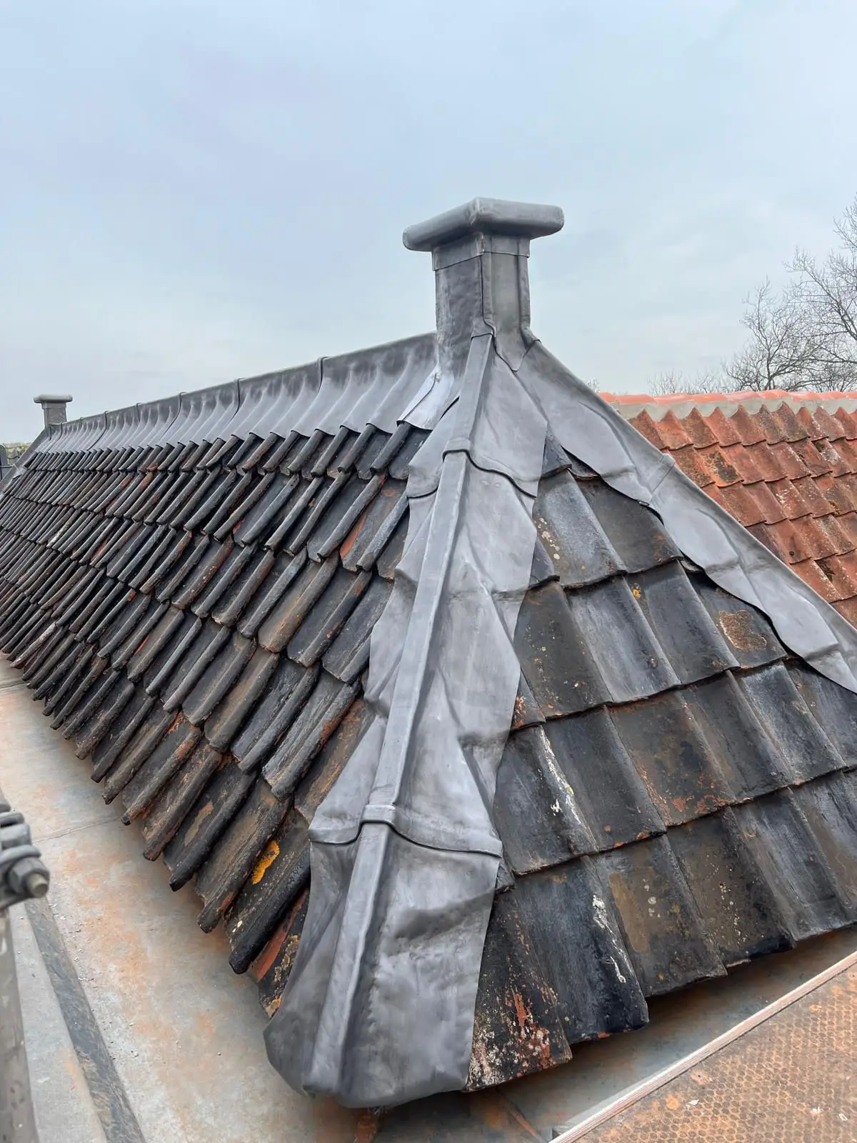 Nieuwe leien dakbedekking met dakkapel op het monumentale pand