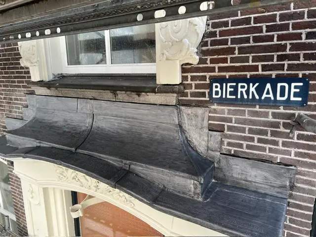 Nieuwe dakbedekking met loodslabben langs de daklijst van het pand