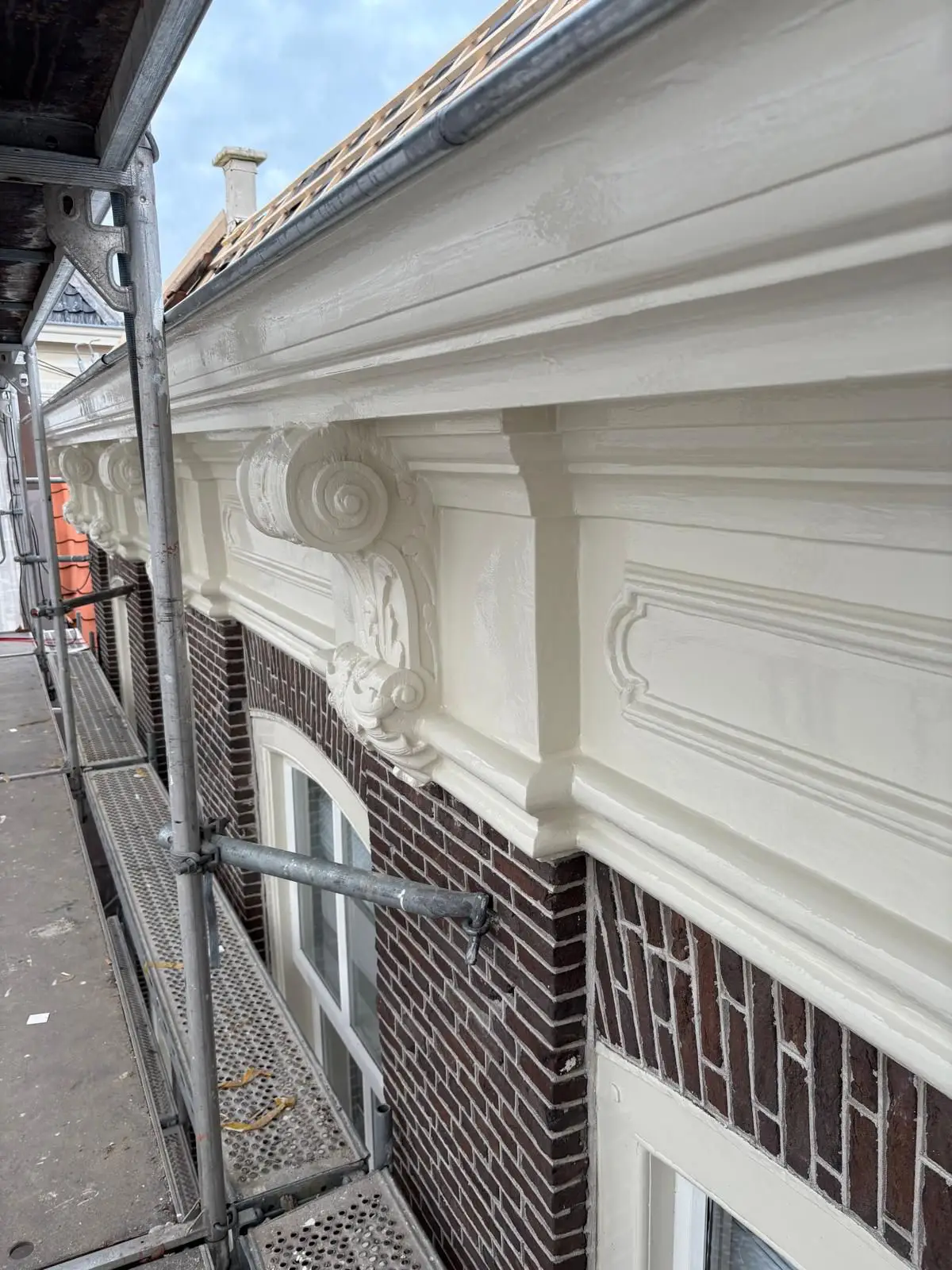 Gerestaureerde witte kroonlijst langs de gevel van het monumentale pand in Purmerend
