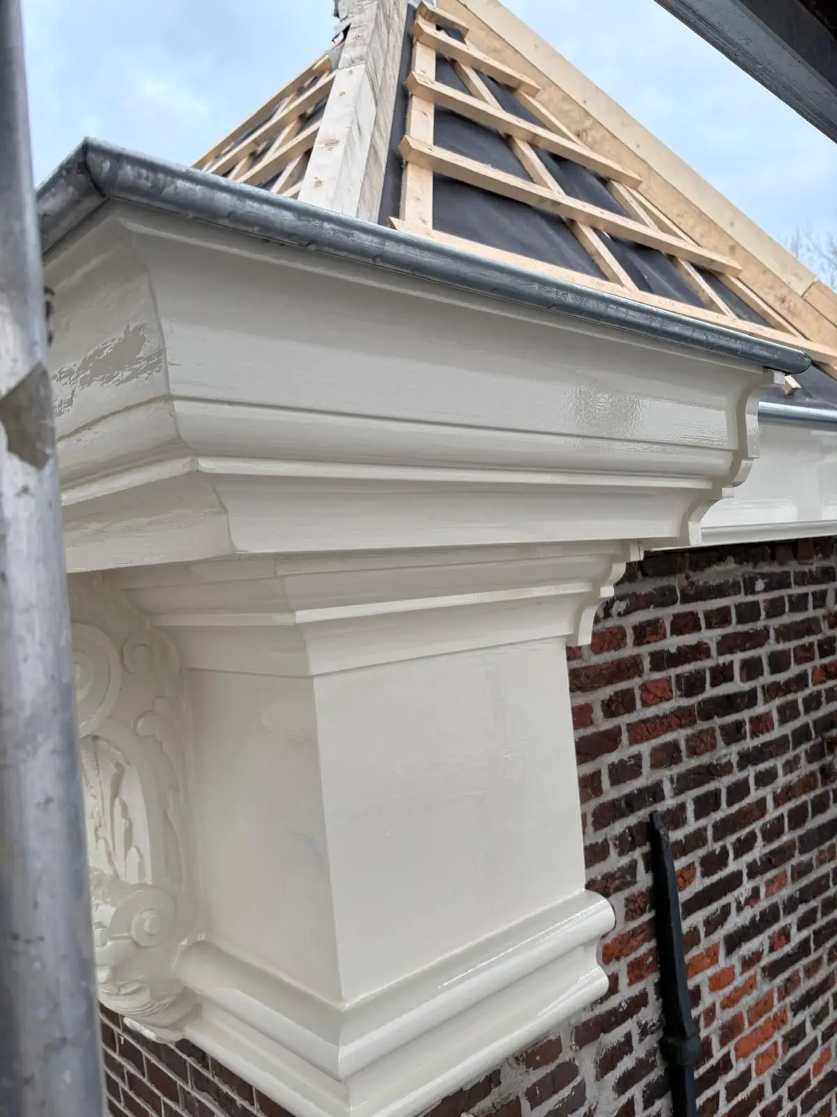 Gerestaureerde witte kroonlijst en geveldetail van een monumentaal pand in Purmerend