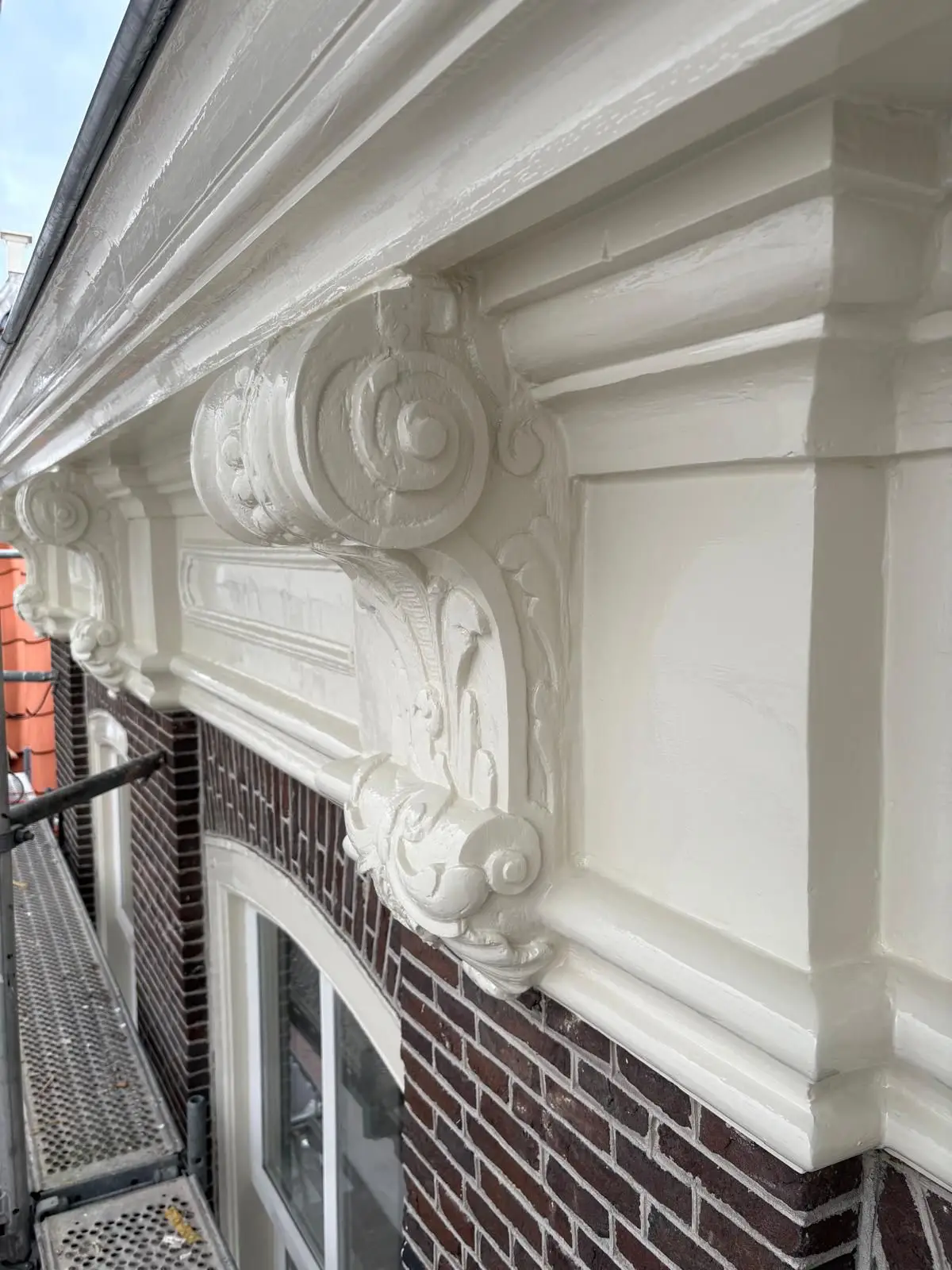 Gerestaureerde gevel met geprofileerde kroonlijst van het monumentale pand