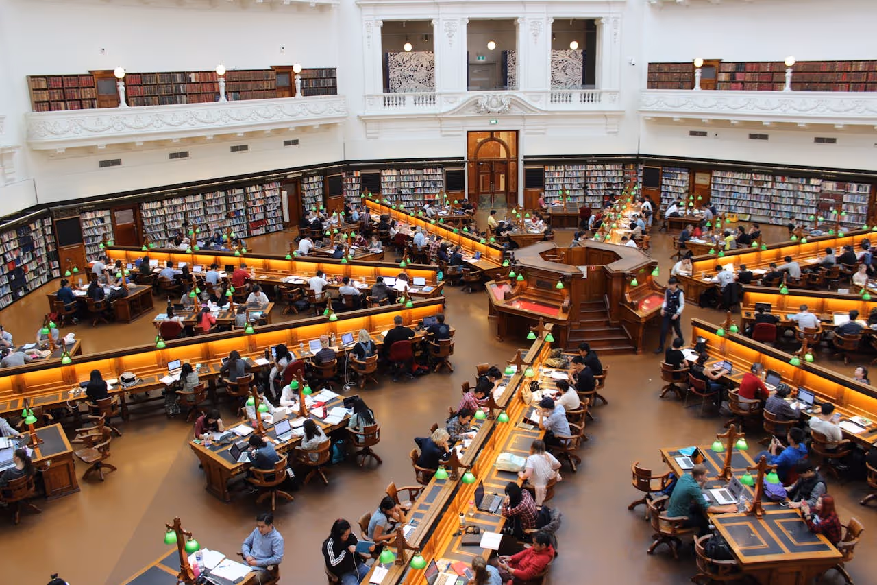 a bunch of students in a busy library.