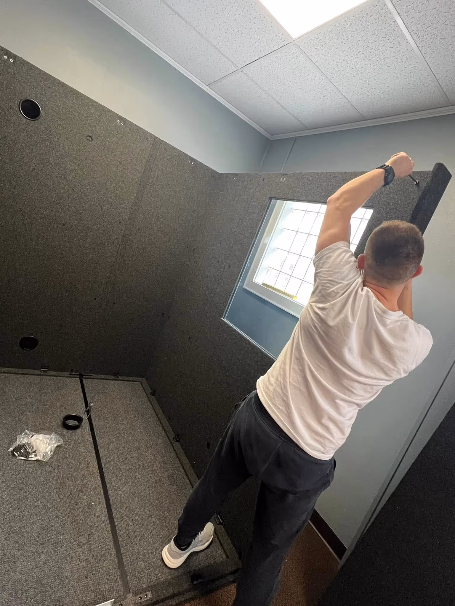 one man putting together a WhisperRoom audiometric booth inside of a clinic. Showing the ease of assembly by the end user.
