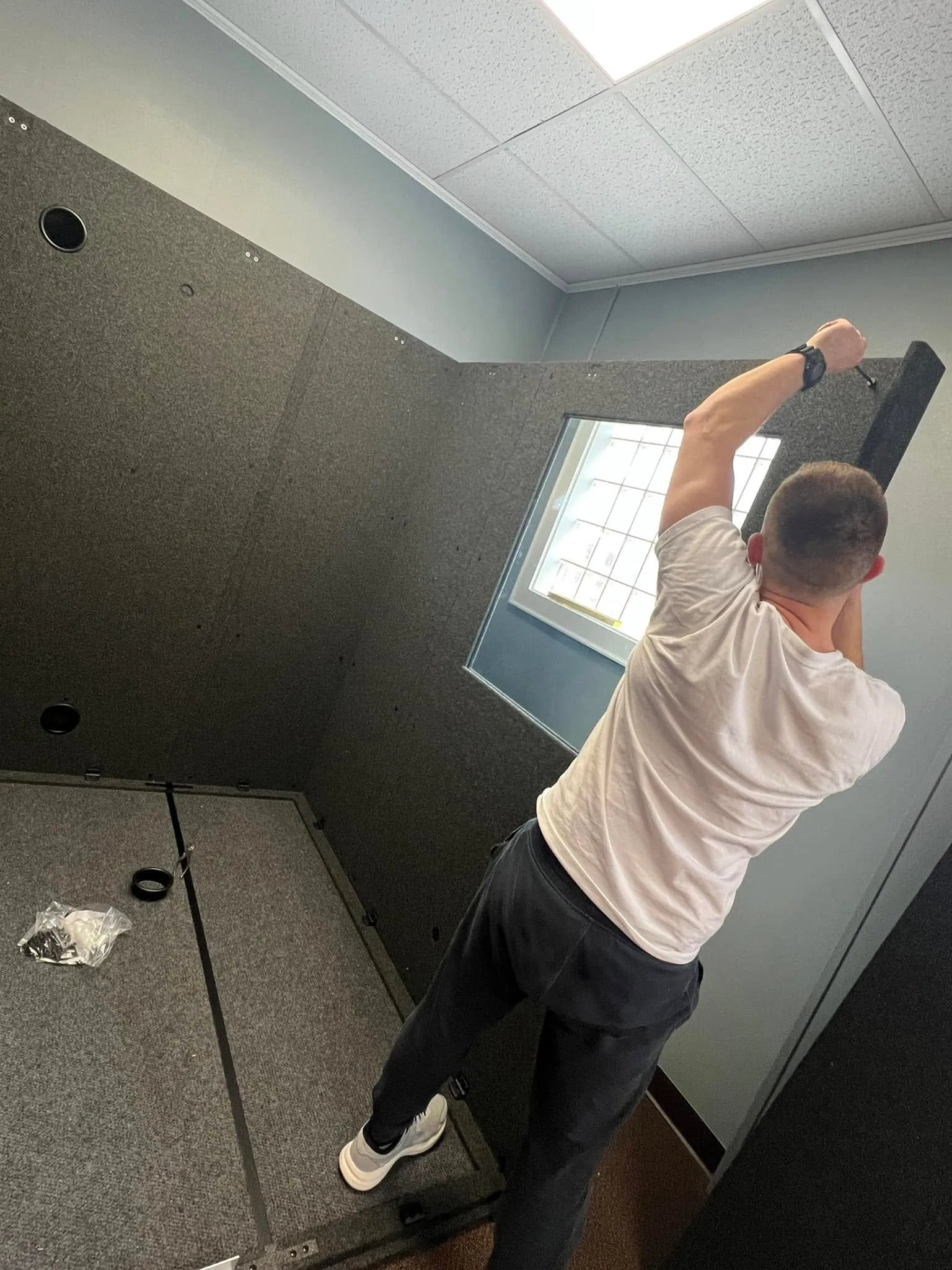 one man putting together a WhisperRoom audiometric booth inside of a clinic. Showing the ease of assembly by the end user.
