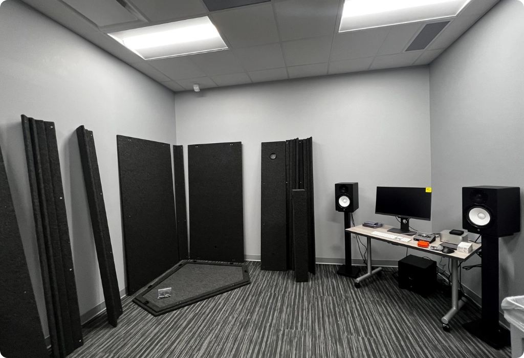 WhisperRoom sound booth panels laid out in a studio, showing modular components ready for assembly.