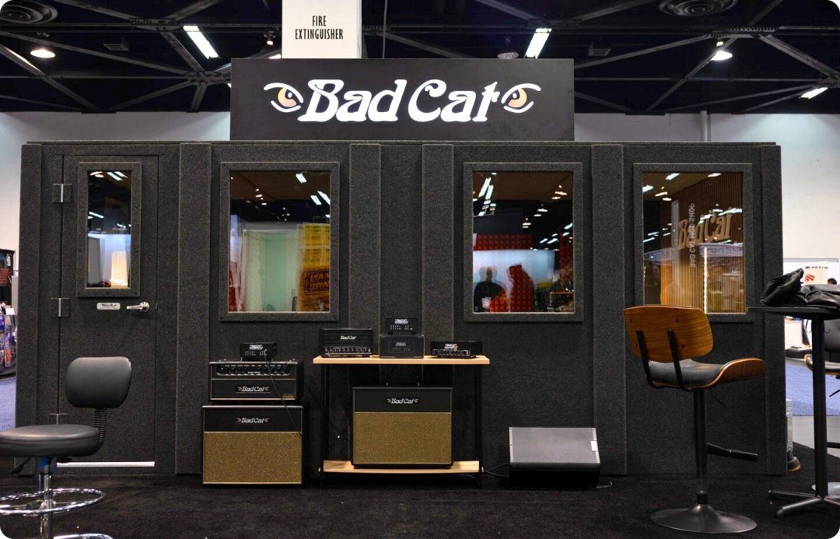 Bad Cat exhibitor booth featuring a WhisperRoom sound isolation booth on a busy trade show floor