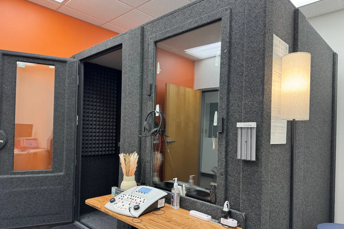 WhisperRoom audiometric booth with observation window and audiometer installed in a clinical testing room.