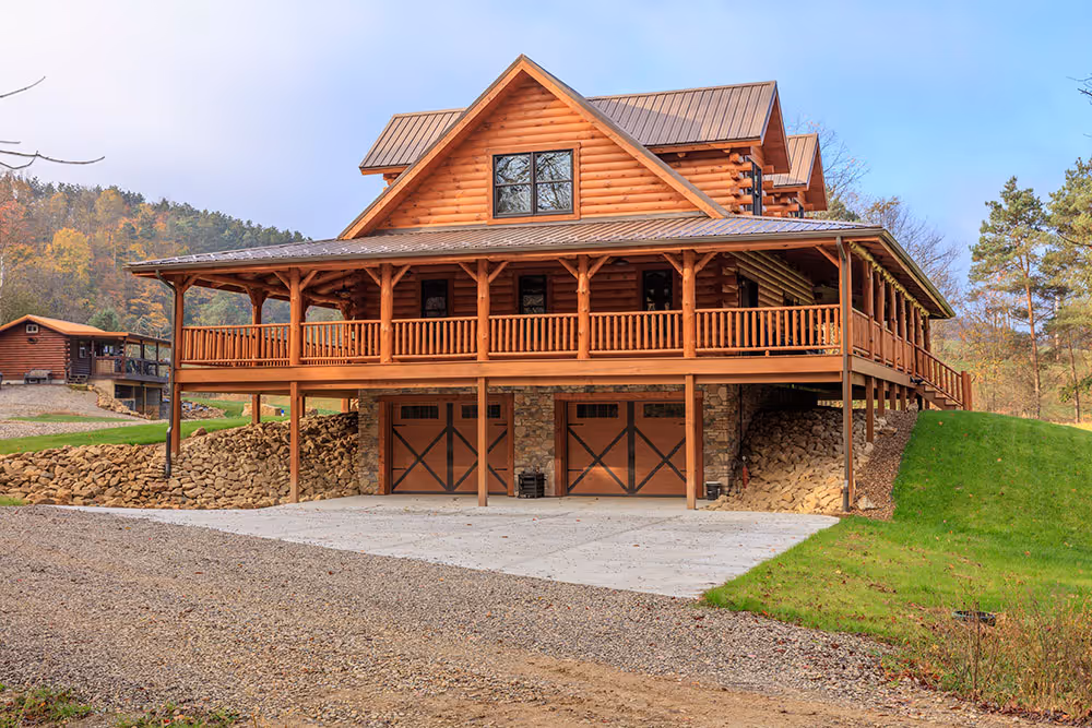 Durable log home with solid wood walls, wraparound porch and stone lower level in a wooded setting.