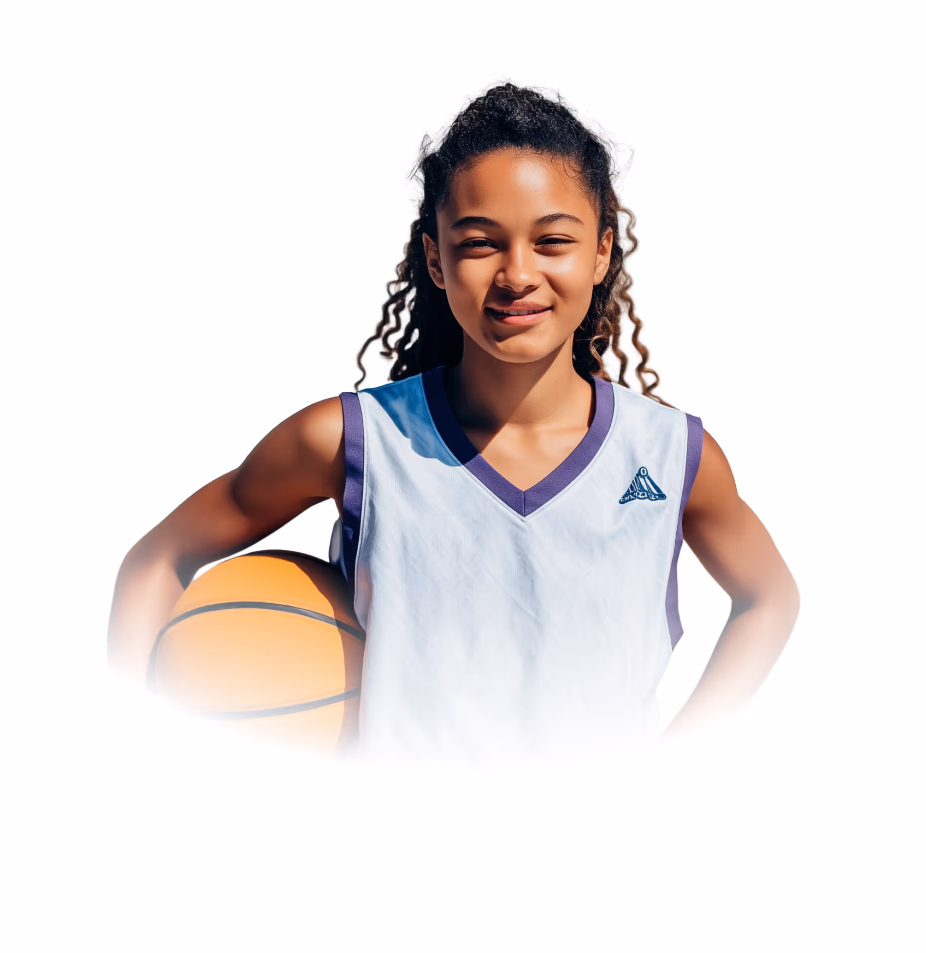Young girl in a basketball jersey holding a basketball with a confident smile.