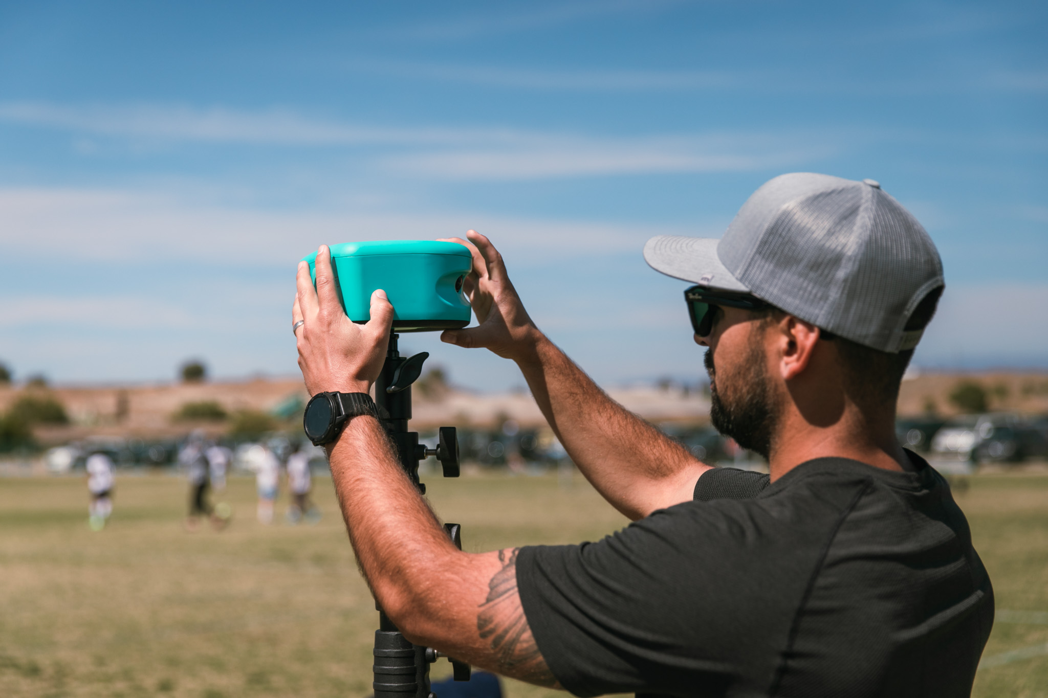 A man setting up his TraceCam and tripod