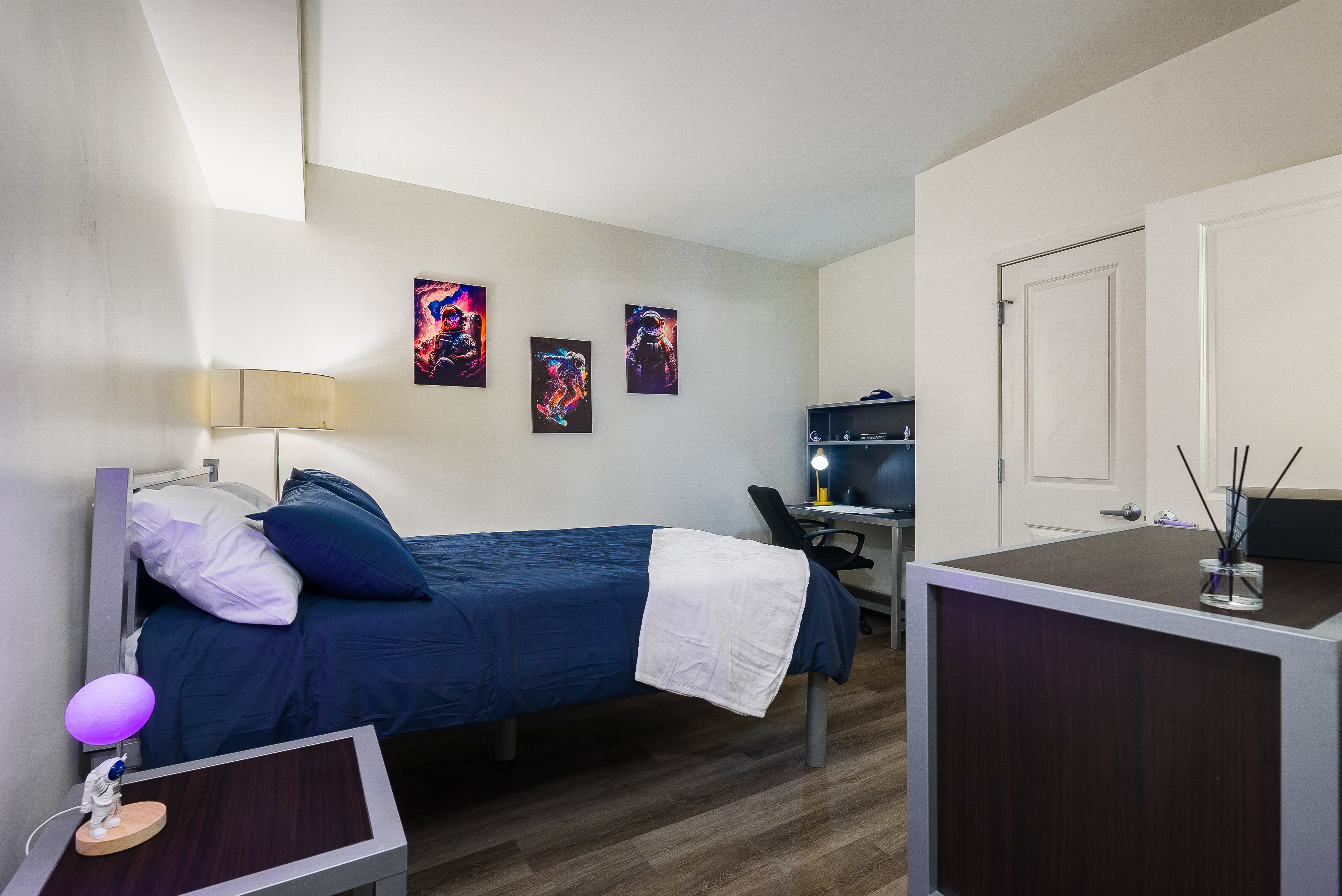 Bedroom with bed, lamp, and desk with chair