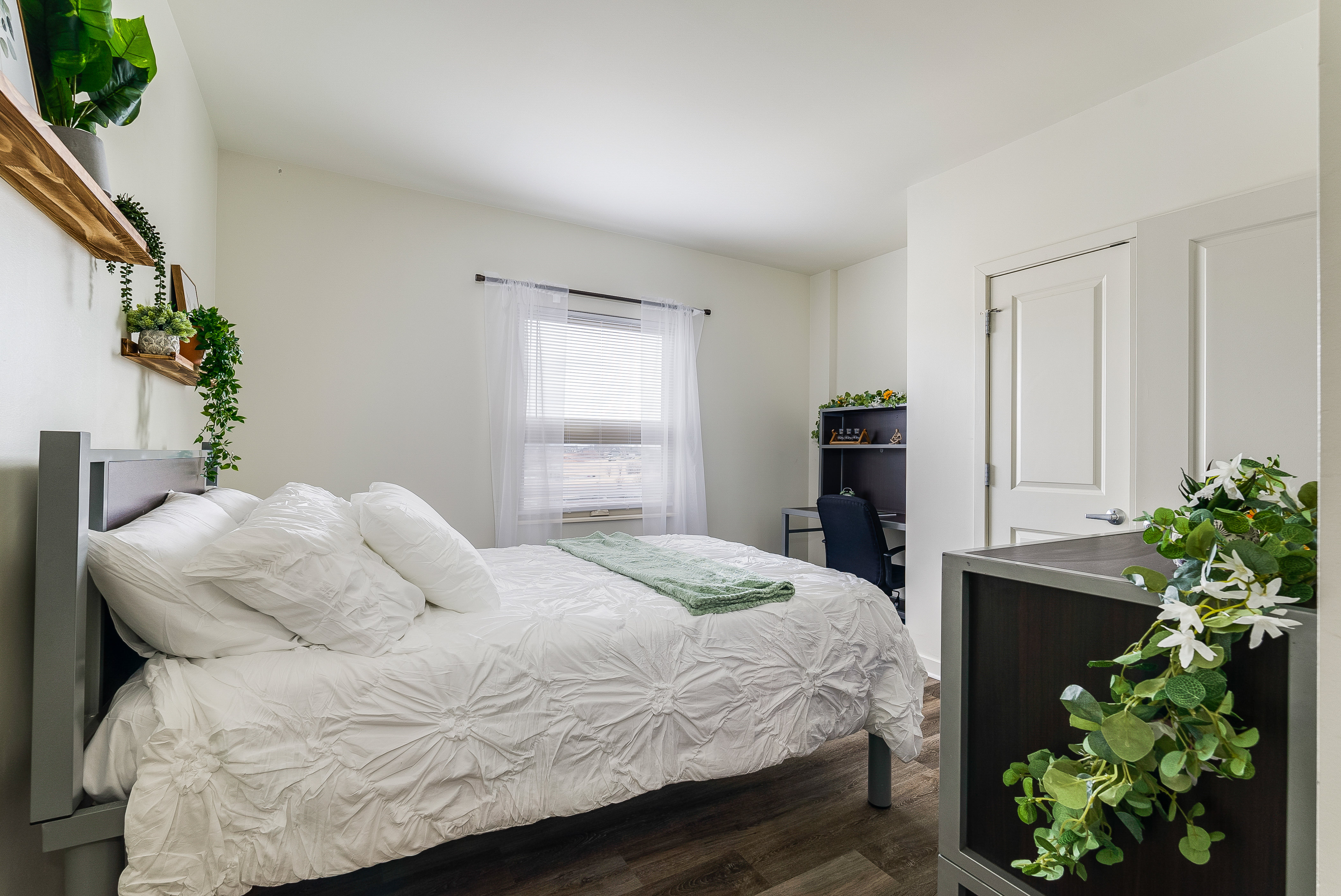Bedroom with bed and desk with chair and view into bathroom