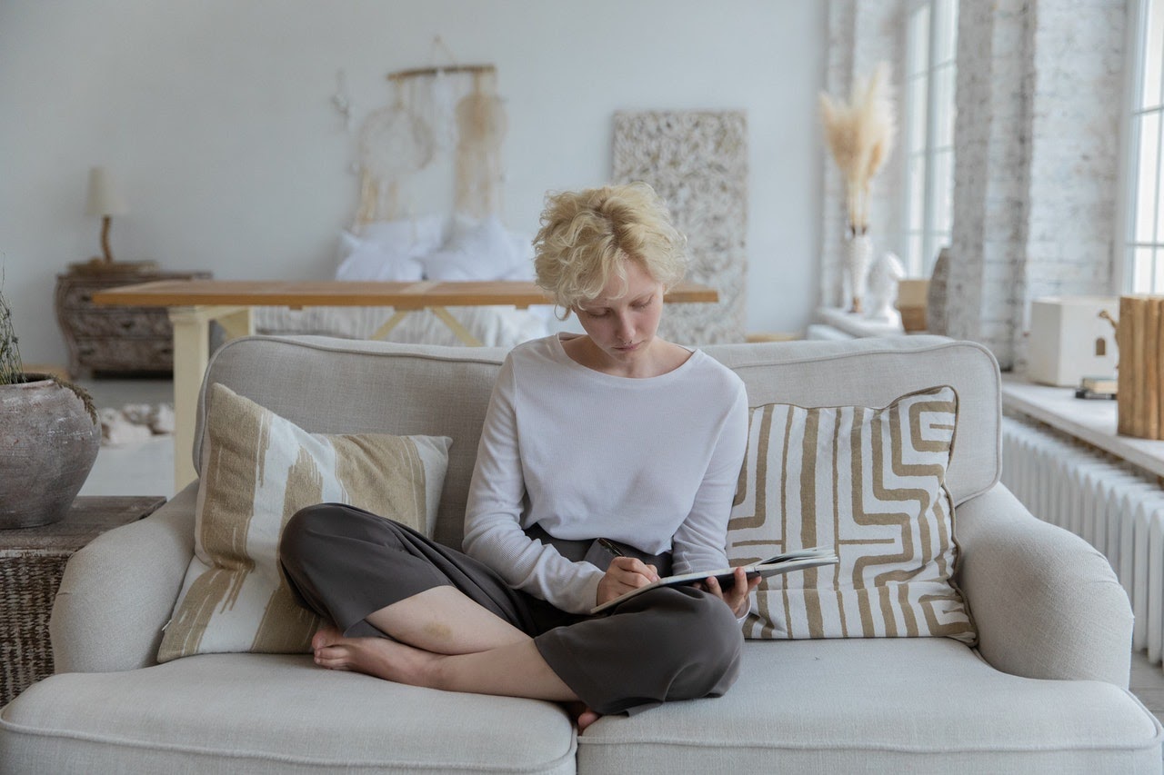 a woman sitting on a couch brainstorming blog ideas