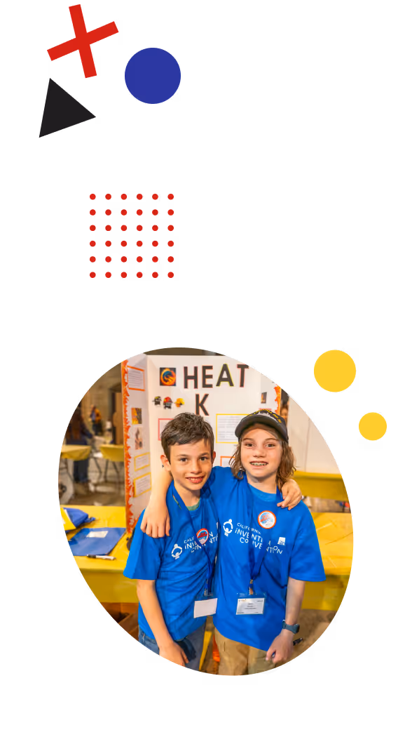 Two smiling young boys in a CAIC shirt, standing in front of their invention poster board