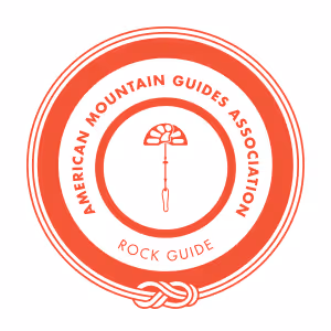 Red and white circular logo of the American Mountain Guides Association, labeled "Rock Guide."