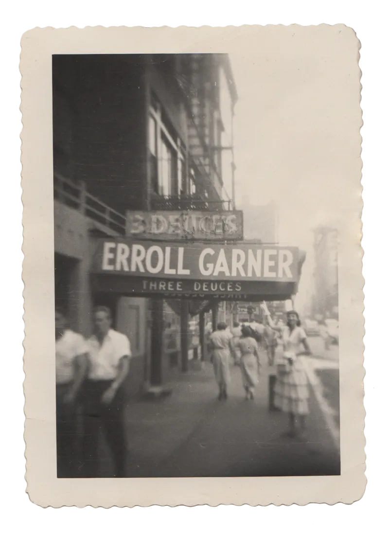 Vintage black and white photo of pedestrians walking past a theater marquee advertising Erroll Garner's Three Deuces.