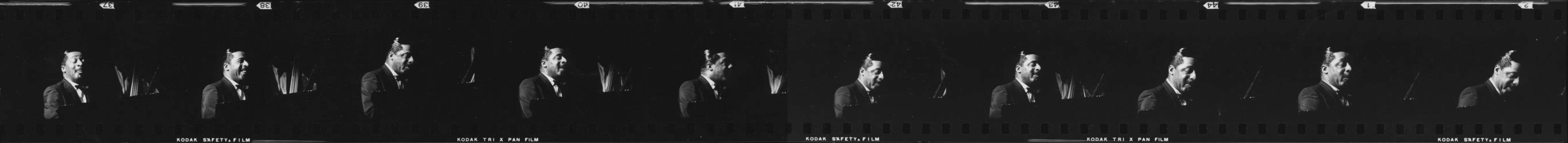 Black and white film strip with repeated frames of Erroll Garner in a suit smiling and looking left in a dark setting.