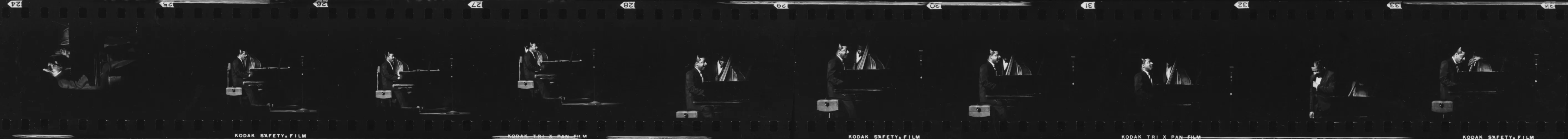 Black and white film strip showing Erroll Garner in a suit playing the piano from various angles.