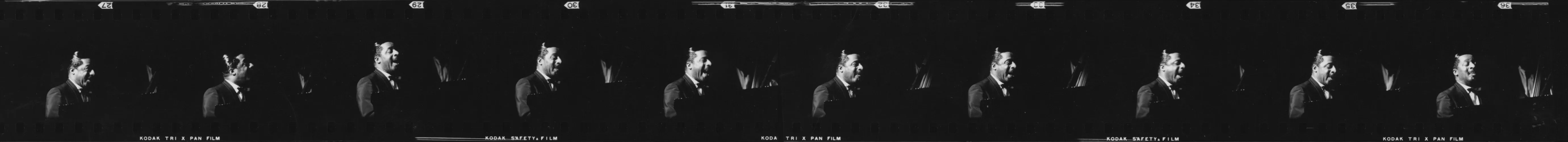 Black and white film strip showing repeated images of Erroll Garner gesturing or speaking in profile against a dark background.