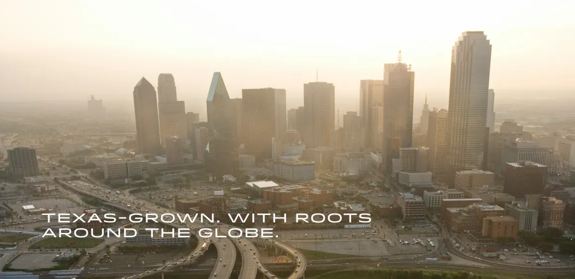 Aerial view of a Texas city skyline with highways and buildings at sunset, text says Texas-grown with roots around the globe.