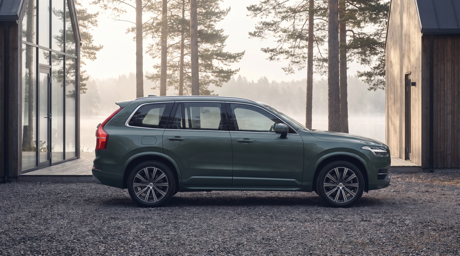 Grand SUV familial devant une maison au bord d'un lac nordique