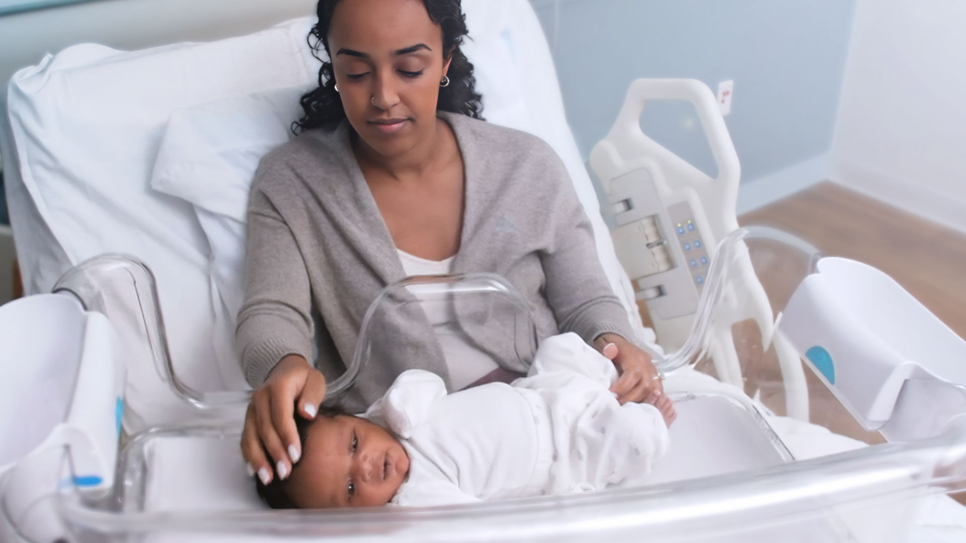 A mother accessing her baby through our groundbreaking bassinet