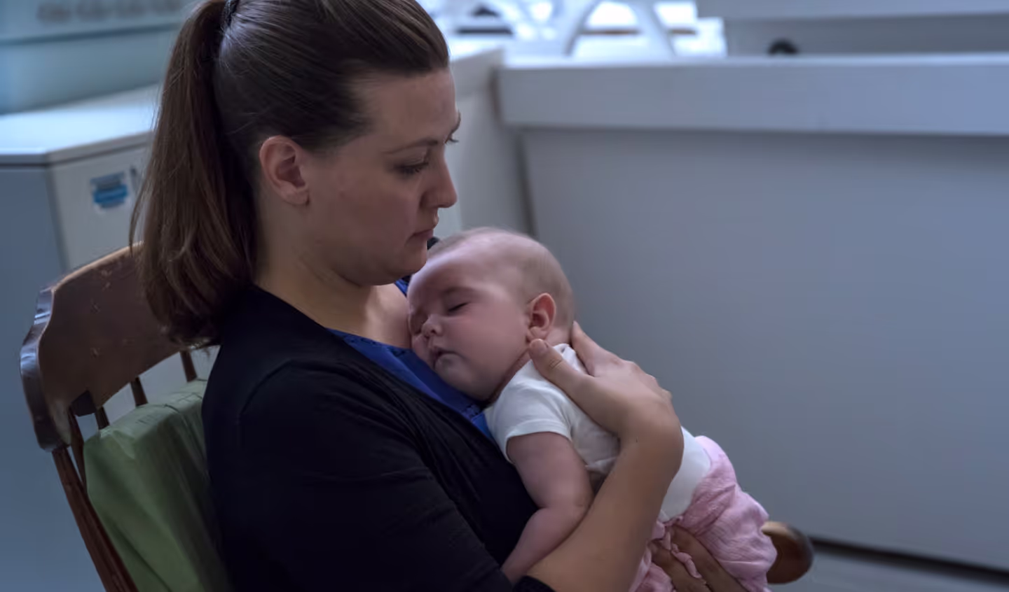 A smiling mother breastfeeding her newborn